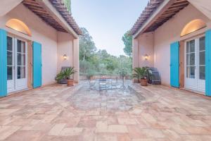 un patio extérieur avec des tables et des chaises dans un bâtiment dans l'établissement Villa élégante à Ramatuelle + Piscine, à Ramatuelle