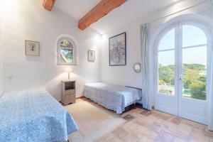 une chambre avec deux lits et une fenêtre dans l'établissement Villa élégante à Ramatuelle + Piscine, à Ramatuelle