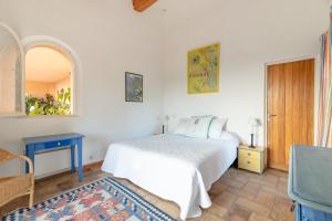 - une chambre avec un lit et une table bleue dans l'établissement Villa élégante à Ramatuelle + Piscine, à Ramatuelle