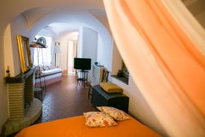 a bedroom with an orange bed and a living room at BB Le Gemme in Dolceacqua
