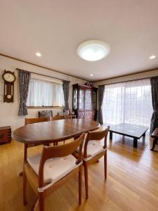 a dining room with a table and chairs and a living room at Young House in Matsudo