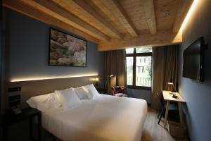a bedroom with a large white bed and a television at M&UGA Hotela in Elorrio +41 photos