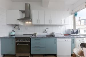 a kitchen with white cabinets and a stove top oven at Casa Da Tapada - Alcantara Riverview Apartment in Lisbon