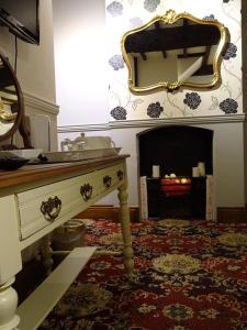 a living room with a table and a fireplace at The Grange at Mortimers Cross 
