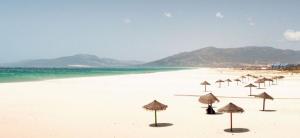 - un groupe de parasols sur une plage donnant sur l'océan dans l'établissement La Casa del Tio Sam, à Tarifa