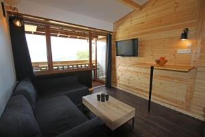 ein Wohnzimmer mit einem Sofa und einem Tisch in der Unterkunft Studio LUMINEUX à 5 minutes du lac de Serre Ponçon in Prunières