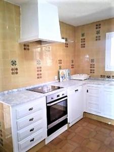 a kitchen with white cabinets and a sink and a stove at Maria 10 in Jávea