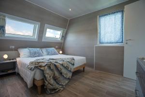 een slaapkamer met een bed en 2 ramen bij Marina houseboat 2 pax in Lignano Sabbiadoro