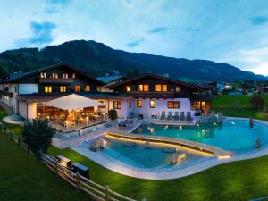 an aerial view of a house with a large swimming pool at Hotel Quehenberger in Maishofen