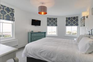 een slaapkamer met een wit bed en 2 ramen bij Master accommodation suite 7 sea view in Hastings