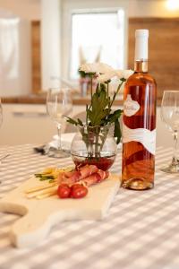 a bottle of wine and some vegetables on a table at Studio apartman Amalie in Pazin