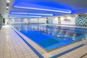 a large indoor swimming pool with blue water at Crow Wood Hotel & Spa Resort in Burnley