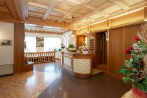 Habitación grande con techo de madera y bar. en Albergo Alla Comparsa, en Baselga di Pinè