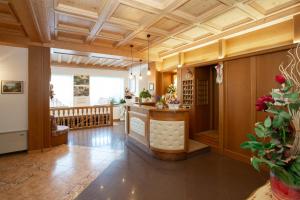 a large room with a wooden ceiling and a bar at Albergo Alla Comparsa in Baselga di Pinè