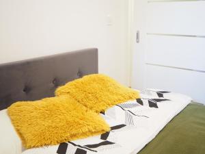 a bed with two yellow pillows on it at Telimeny in Kraków