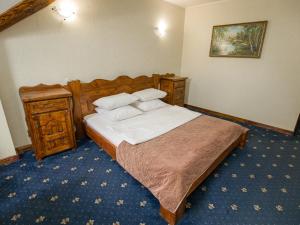 1 dormitorio con 1 cama con sábanas y almohadas blancas en Yuzhny Dvorik, en Leninskiye Gorki