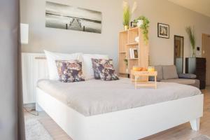 uma grande cama branca num quarto com um sofá em Easy Rent Apartments - BUSINESS CENTER 126 em Lublin