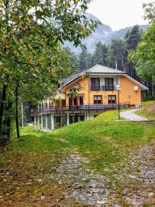 uma casa amarela no topo de uma colina em La Locanda Della Pineta em Bertonio