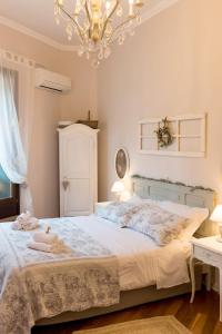 sypialnia z łóżkiem i żyrandolem w obiekcie La Mansarda Segreta Mood Apartment w Weronie