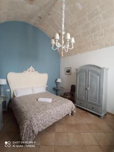 - une chambre avec un lit et un lustre dans l'établissement B&B La Porta Vecchia, à Monopoli