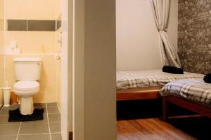 a small bathroom with a toilet and a bed at Edinburgh Backpackers in Edinburgh