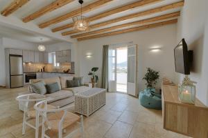 un salon avec un canapé et une télévision et une cuisine dans l'établissement Agapi's Houses, à Andiparos