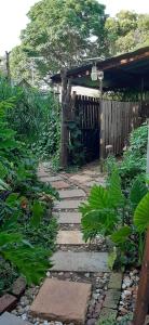 un giardino con passerella in pietra di fronte a una recinzione di Wooden Creek Estate a Kempton Park