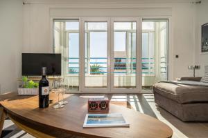 a living room with a table with a bottle of wine at Mar Apartment in Altea