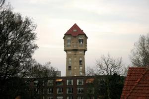 a tall tower with a clock on top of a building at Hotel Royal in IJmuiden