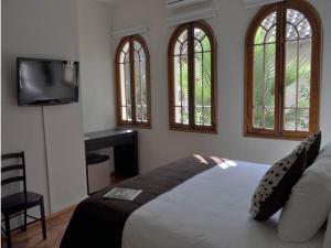 a bedroom with a bed and a flat screen tv at Hotel CasaDeTodos in Santiago