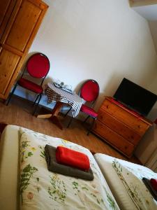 um quarto com uma cama, 2 cadeiras e uma mesa em Penzión Pod orechom em Turčianske Teplice