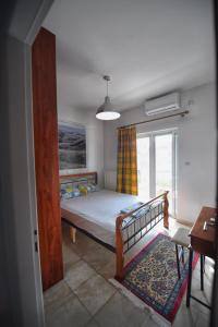 1 dormitorio con cama y ventana en Maisonette Ilios, en Plisioí