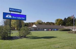 a sign for the best value inn in a field at Best Inn in Wellsville