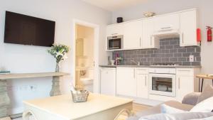 uma cozinha com armários brancos e uma mesa num quarto em Modern Apartment with FREE Parking, WIFI and Netflix em Stratford-upon-Avon