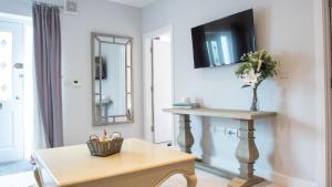 Una sala de estar con una mesa y un televisor en la pared. en Modern Apartment with FREE Parking and WiFi, en Stratford-upon-Avon 14 fotos más