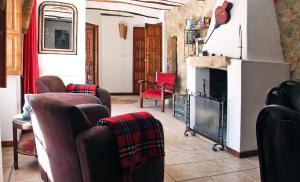 ein Wohnzimmer mit Sofas und einem Kamin in der Unterkunft Appartement El Patio (cortijo La Cubertilla) in Fuente-Tójar