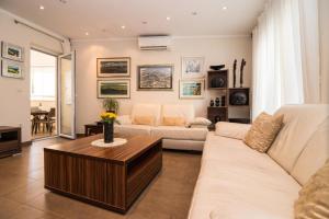 Apartment Iris في دوبروفنيك: غرفة معيشة مع أريكة بيضاء وطاولة قهوة