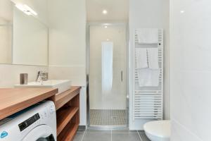 een badkamer met een wastafel en een wasmachine. bij VILLA14 in Dijon
