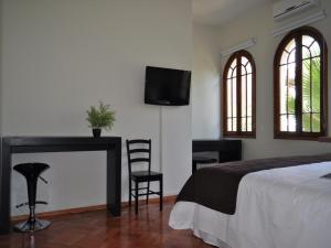 a hotel room with a bed, tv and a window at Hotel CasaDeTodos in Santiago