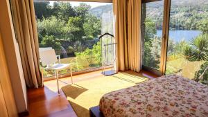 a room with a bed and a large window at Eira House - Quinta de Fundevila in Vieira do Minho