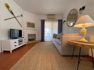 a living room with a couch and a television at Quinta do Lago Golf in Quinta do Lago