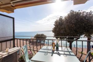 a table on a balcony with a view of the ocean at I love Nice - FACE MER, DESIGN, TERRASSE, ASC, WIFI, CLIM in Nice
