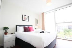 a bedroom with a large bed and a large window at Cotels at The HUB Serviced Apartments, Superfast Broadband, Central Location, Free Parking in Milton Keynes