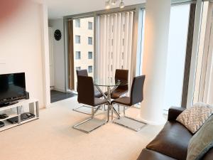a living room with a glass table and chairs at Cotels at The HUB Serviced Apartments, Superfast Broadband, Central Location, Free Parking in Milton Keynes