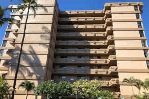 a tall building with palm trees in front of it at Maui Kai 507 in Honokowai