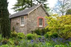 uma velha casa de pedra com flores em frente em Courtyard Cottage em Oswestry