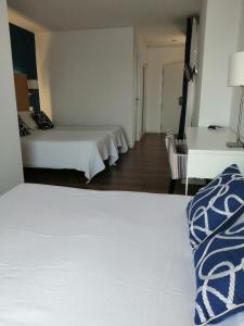 a hotel room with two beds and a desk at Hotel Llorca in Platja de l’Almadrava