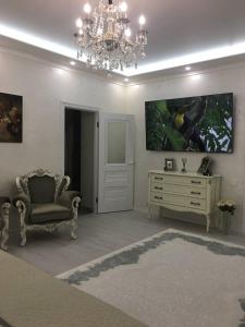 - un salon avec un lustre, une chaise et une commode dans l'établissement Sobor, à Vinnytsia