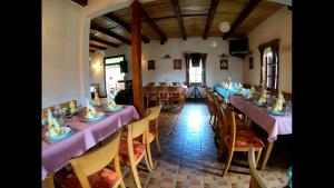 uma sala de jantar com mesas e cadeiras roxas em Etno village Gostoljublje em Kosjerić