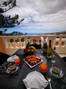 a table with a tray of food and a plate of fruit at Ocean View Apartment in Adeje